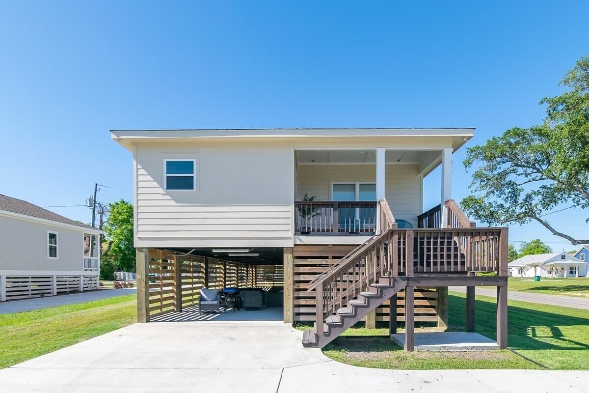 A two-story house with a covered garage and a wooden deck.