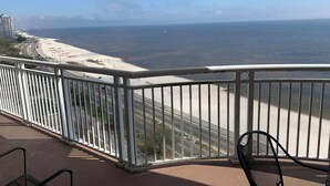 Un balcon avec vue sur une plage et une autoroute.
