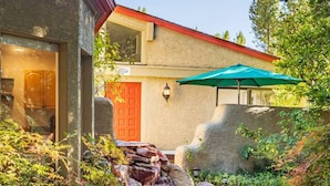 A landscaped garden with a stone water feature, a red door, and a sign indicating Villa Casita. - Lush Backyard, Hot Tub, Grill, Covered Patio (Sedona)