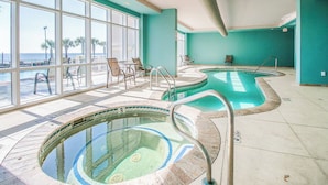 A pool area with two hot tubs, a seating area with chairs, and large windows offering a view of the ocean. - Beachview Condo at Legacy Tower 2 -1103 - Fully Furnished 2 Bedroom 2 Bath (Gulfport)