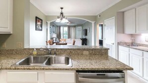 A kitchen with granite countertops, stainless steel appliances, and white cabinetry. - Beachview Condo in Legacy Tower1 -303 - With Reserved Parking Spot in Front (Gulfport)