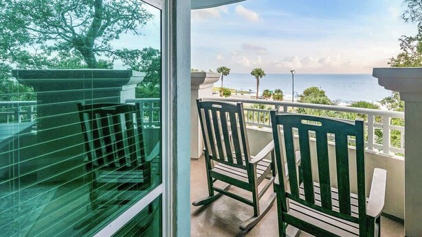 A balcony with two rocking chairs and a view of the ocean. - Beachview Condo in Legacy Tower1 -303 - With Reserved Parking Spot in Front (Gulfport)