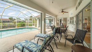 A covered outdoor area with a pool, lounge chairs, and ceiling fans. - Sunshine Vibes • Pool, Hot Tub & Kayaks (Cape Coral)