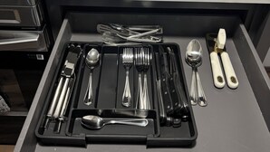 A kitchen with a drawer containing utensils, a black mug labeled "UTENSIL," and jars labeled "SWEET" and "SAW." -  Modern 4BR/2.5BA Townhouse in the Heart of Fort Worth (Fort Worth)