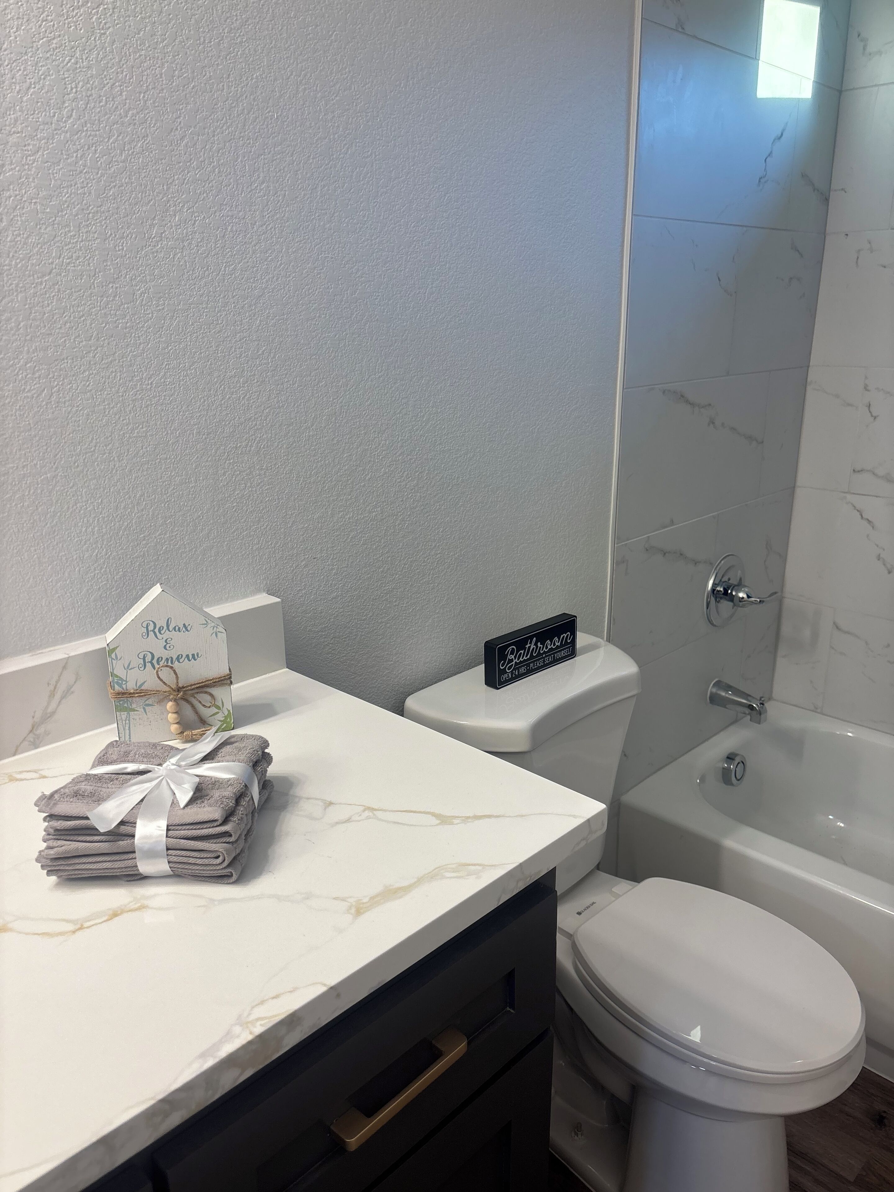 Een badkamer met een marmeren aanrecht, een toilet en een bad.