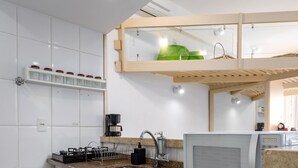 A modern kitchen with white cabinets, a granite countertop, a built-in microwave, and a coffee maker. - 1 Minuto Da Praia De Copacabana | A923 (Rio de Janeiro)