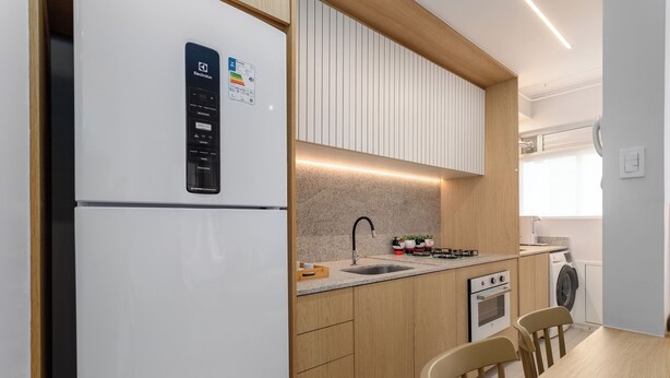 A compact kitchen with a built-in refrigerator, a sink, a stove, and a washing machine. - Luxo Na Barra Da Tijuca Próximo Ao Parque Olímpico | Av806 (Rio de Janeiro)