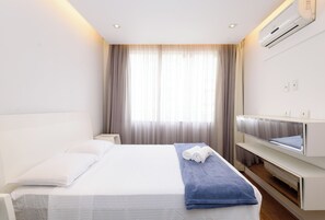 A hotel room with a bed, a bedside table, a mirror, and a window with curtains. - Iluminado Em Copacabana |Paisagem Leve| Bc706 (Rio de Janeiro)