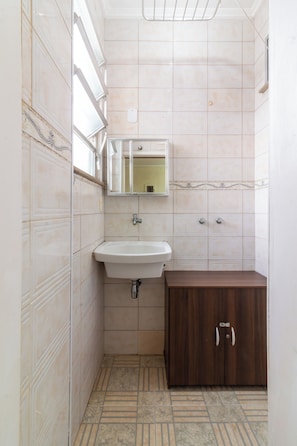 Un bagno piccolo con lavandino, specchio e mobiletto.