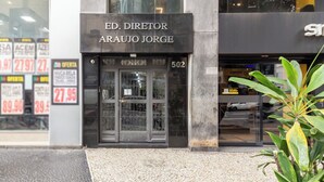 Der Eingang eines Gebäudes mit einem Schild, auf dem 'ED. DIRETOR ARAUJO JORGE' steht und der Zahl '502' über der Tür.