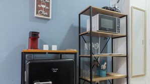A compact kitchen area with a black refrigerator, a microwave on a shelf, and a small cabinet. - 5Min Da Praia De Copacabana | Br902 (Rio de Janeiro)