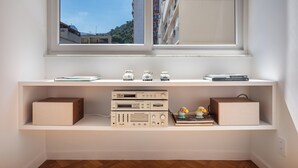 A room with a large window, a white desk with shelves, and electronic equipment. - 5 Minutos Da Praia E Vista Para O Cristo | Br904 (Rio de Janeiro)