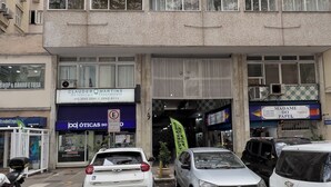 A multi-story building with several ground-floor commercial spaces, including a shop and a medical office. - Aconchego Em Copa | Ideal P/ Família | Brx1005 (Rio de Janeiro)