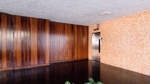A spacious lobby with dark wooden paneling and a tiled floor, leading to an elevator. - Excelente Em Ipanema |Ambiente Familiar| Bt101 (Rio de Janeiro)