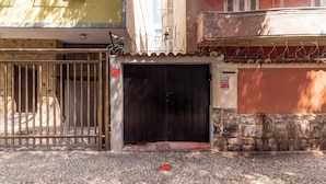 Μια πύλη που κλείνει με συρόμενη ή ανοιγόμενη κατασκευή, η οποία οδηγεί σε ένα κτίριο με πλακόστρωτο δρόμο πρόσβασης.
