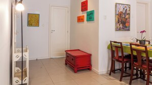 A dining area with a table set for four, a red crate, and a floor lamp. - 7 Minutos Da Praia De Ipanema | Bt201 (Rio de Janeiro)
