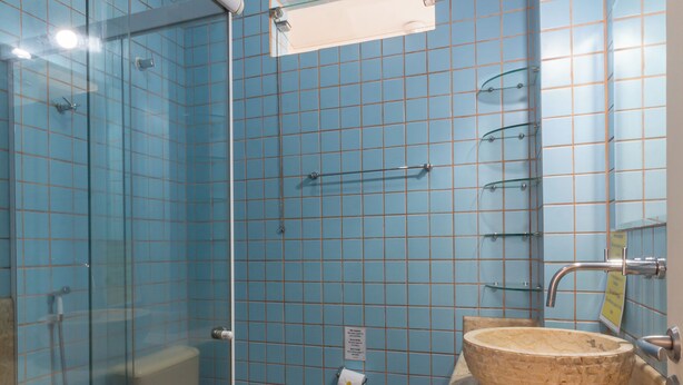 A bathroom with a glass-enclosed shower, a toilet, and a sink with a beige basin. - 7 Minutos Da Praia De Ipanema | Bt201 (Rio de Janeiro)