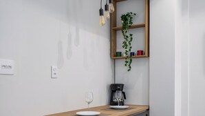 Un espace de salle à manger moderne avec une table en bois, des chaises noires et des lampes suspendues.