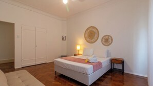 A bedroom with a bed, bedside tables, a lamp, and a door. - Espaço E Conforto Em Copacabana | D405 (Rio de Janeiro)
