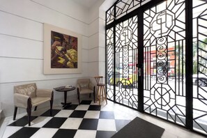 A lobby with a checkered floor, two sofas, a small table, and a large abstract painting. - 2 Minutos Da Praia De Copacabana | Df408 (Rio de Janeiro)