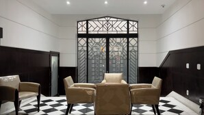 A room with a checkered floor, four beige chairs, and a decorative partition with geometric patterns. - 2 Minutos Da Praia De Copacabana | Df408 (Rio de Janeiro)