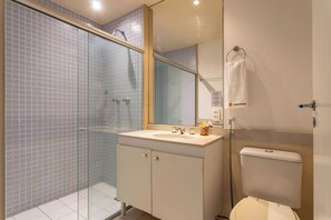 A bathroom with a glass shower enclosure, a sink with a mirror above it, and a toilet. - 2 Minutos Da Praia De Copacabana | Df408 (Rio de Janeiro)