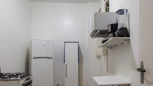 A compact kitchen with white appliances, a gas stove, a refrigerator, and a sink. - 6 Minutos Da Praia De Copacabana | El108 (Rio de Janeiro)