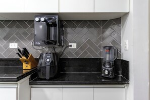 A kitchen with a black countertop, a coffee maker, a blender, and a knife block. - 3 Minutos Da Praia Do Leme | Grc701 (Rio de Janeiro)