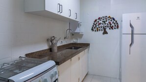A kitchen with white cabinets, a stove, a sink, and a refrigerator. - 5 Minutos Da Praia Do Leme | Gs1102 (Rio de Janeiro)