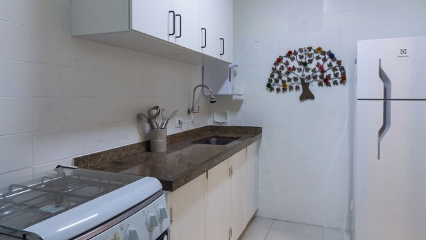 A kitchen with white cabinets, a stove, a sink, and a refrigerator. - 5 Minutos Da Praia Do Leme | Gs1102 (Rio de Janeiro)