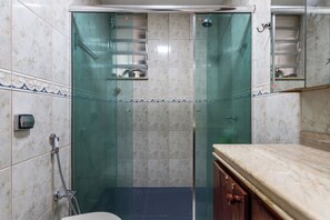 A bathroom with a glass-enclosed shower, marble tiles, and a wooden cabinet. - 3 Minutos Da Praia Do Leme | Gs501 (Rio de Janeiro)