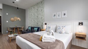 Una camera d'albergo moderna con un letto, comodini, una scrivania e una sedia.