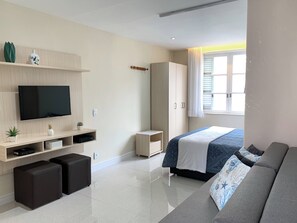 A modern bedroom with a bed, a sofa, a TV, and a wardrobe. - 6 Minutos Da Praia De Ipanema E Próximo Do Metrô | J801 (Rio de Janeiro)
