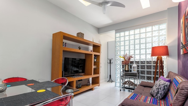 A modern living room with a TV, sofa, and dining table. - Estudio Moderno Do Lado De Arpoador | Jc1012 Z2 (Rio de Janeiro)