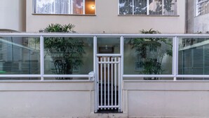 A building facade with a gated entrance, large windows, and potted plants. - 3 Minutos Da Praia Do Arpoador | Jn202 (Rio de Janeiro)