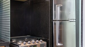 Een keuken met een roestvrijstalen kookplaat, oven en koelkast.