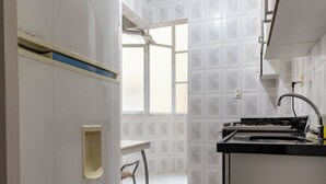 A kitchen with white tiled walls, a sink, and a window. - 3 Minutos Da Praia De Ipanema | Pm203 (Rio de Janeiro)