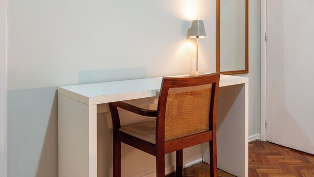 A small, neatly arranged room with a desk, chair, and a mirror. - 3 Minutos Da Praia De Ipanema | Pm203 (Rio de Janeiro)