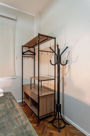 A bunk bed with a wooden frame and metal hooks, a small shelf, and a window with a blind. - 3 Minutos Da Praia De Ipanema | Pm203 (Rio de Janeiro)