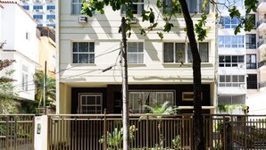 A multi-story building with a gated entrance, air conditioning units, and a balcony with plants. - 3 Minutos Da Praia De Ipanema | Pm402 (Rio de Janeiro)