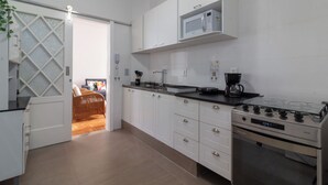 A modern kitchen with white cabinets, a gas stove, and a microwave. - Sofisticado A Poucos Passos Da Lagoa | Sb301 (Rio de Janeiro)