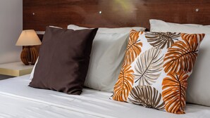 A neatly made bed with white linens and two decorative pillows, one brown and one with a leaf pattern. - Agradável Em Copa | Ideal Para Amigos | Sc602 (Rio de Janeiro)