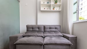 A grey sectional sofa with a white shelf above it. - Agradável Em Copa | Ideal Para Amigos | Sc602 (Rio de Janeiro)