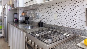 A kitchen with white cabinets, a gas stove, a Bosch oven, a microwave, and a toaster. - 4 Minutos Do Arcos Da Lapa | Sr1502 (Rio de Janeiro)