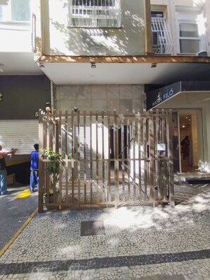 A building entrance with a gated entrance, a tiled pavement, and a sign for 'Maria Filó'. - 3 Minutos Da Praia De Copacabana | Stc303 (Rio de Janeiro)