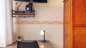 A hotel room with a bed, a desk with a computer, a chair, a TV mounted on the wall, and a wooden wardrobe. - 5 Minutos Da Praia De Copacabana | Stc905 (Rio de Janeiro)