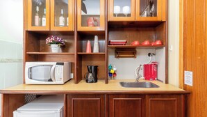 A kitchen with wooden cabinets, a microwave, a coffee maker, and a sink. - 5 Minutos Da Praia De Copacabana | Stc905 (Rio de Janeiro)