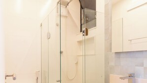 A modern bathroom with a glass-enclosed shower, a toilet, and wooden cabinets. - Aconchegante A Poucos Minutos Da Lagoa | Vlp412 (Rio de Janeiro)