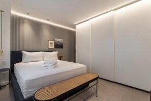 A modern hotel room with a neatly made bed, a bench at the foot of the bed, and a wardrobe with sliding doors. - 10 Minutos Da Praia De Ipanema | Vm201 (Rio de Janeiro)