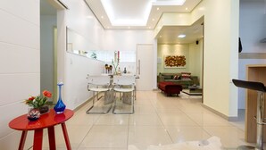 Ein modernes Interieur mit einer zentralen Sitzecke, einem kleinen Tisch mit Dekoration und einer Couch im Hintergrund.